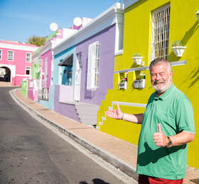 Harry Wijnvoord steht vor einem gelben Haus in Bo-Kaap in Kapstadt